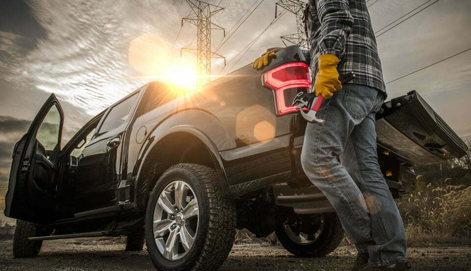 Man som haller hammare kopt av Yrkesbutiken och gar mot sin bil